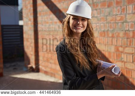 Young Ambitious Lady Posing With A Paper Roll Of Whiteprints