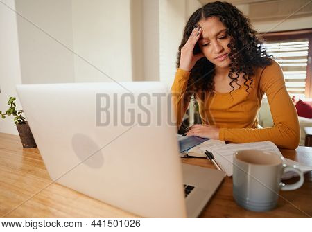 Stressed Multi-cultural Female Concerntraing. Young Professional Remote Working With Laptop In Moder