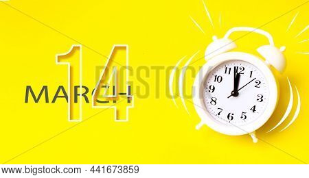 March 14th. Day 14 Of Month, Calendar Date. White Alarm Clock With Calendar Day On Yellow Background