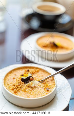Spoon In Creme Brulee Dessert Served With Coffee In Cafe. Natural Light, Vertical, Selective Focus