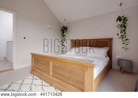 Dry Drayton, England - August 2 2019: Bedroom. Large Wooden Bed And Sidetable Simply Decorated In Sh