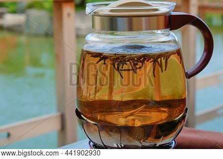 Dancing Floating Opening Green Tea Leaves In Boiling Water Close Up Inside A Transparent Glass Kettl