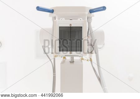 X-ray Department In Modern Hospital. Radiology Room With Scan Machine With Empty Bed. Technician Adj