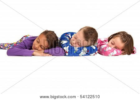 Three Kids Laying Down Asleep In Winter Pajamas
