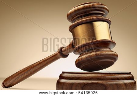A wooden judge gavel and soundboard on brown background in perspective