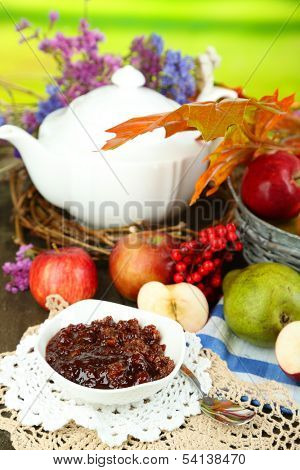 Juicy apples in basket on table on natural background