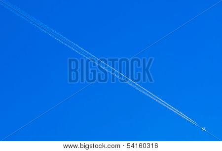Airplane Condensation Trail Going Down On Blue Sky