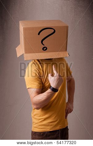 Young man standing and gesturing with a cardboard box on his head with question mark