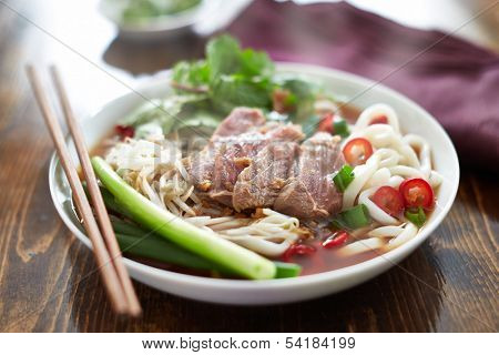 steaming hot bowl of pho with rare beef