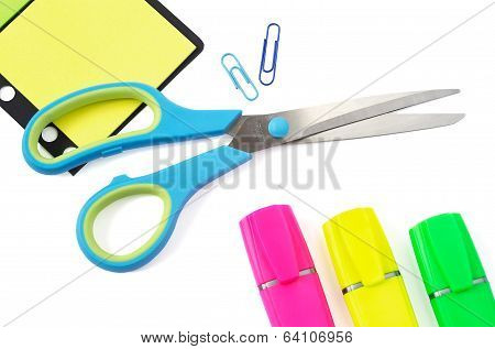 Scissor, Paper Clip, Stikers And Three Highlighter Pens On White Background