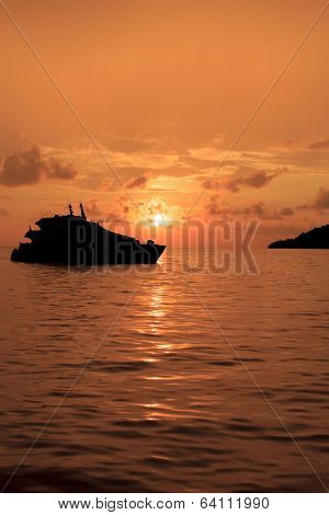Luxury Yacht and island on ocean at sunset