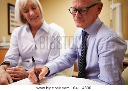 Cosmetic Surgeon Discussing Proceedure With Client In Office