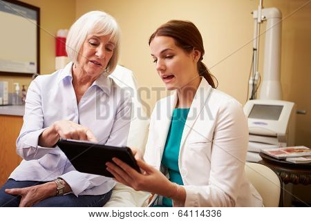 Cosmetic Surgeon Discussing Proceedure With Client In Office