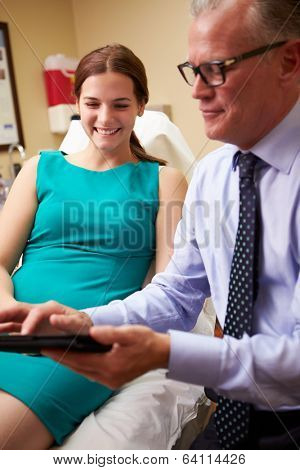 Cosmetic Surgeon Discussing Proceedure With Client In Office