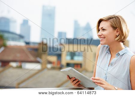 Woman On Roof Terrace Using Digital Tablet