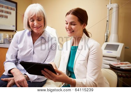 Cosmetic Surgeon Discussing Proceedure With Client In Office