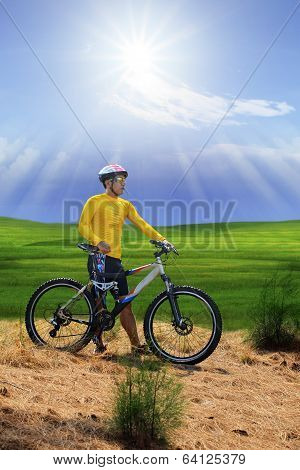Young Man Standing Beside Moutain Bike ,mtb On Hill With Sun Shining On Blue Sky Use For Sport Leisu