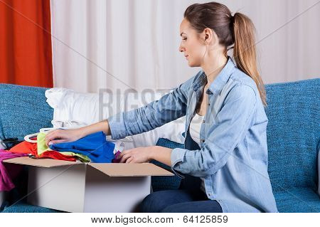 Lady Packing Clothes Into Box