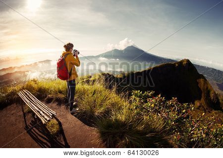 Hiker photographer taking picture of the valley with mountains from view point