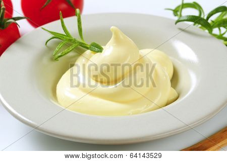 portion of homemade mayonnaise, decorated with herb 