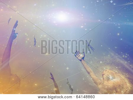 People soaring toward light amongst stars