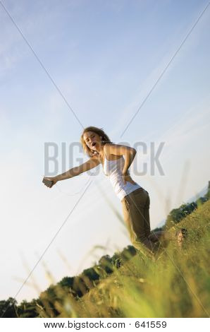 Pěkně dospívající dívka poslouchá přenosný hudební přehrávač