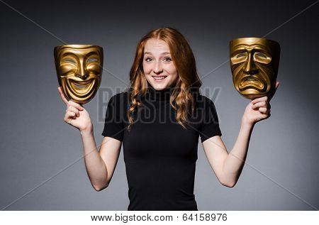 Redhead woman iwith masks in hypocrisy consept against grey background