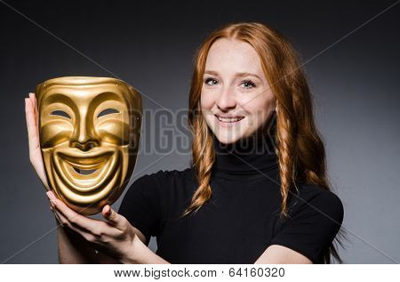 Redhead woman iwith mask in hypocrisy consept against grey background