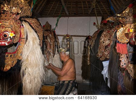 BALI - APRIL 13, 2014: An unidentified master puppeteer prepares the Barong creature to start in a 'Barong' performance in a temple in Bali, Indonesia. The  Barong depicts benevolence overcoming evil.