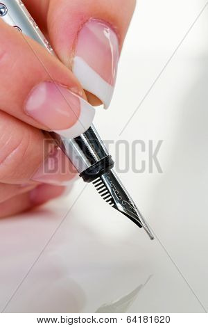 a woman signs a contract or a will with a fountain pen.
