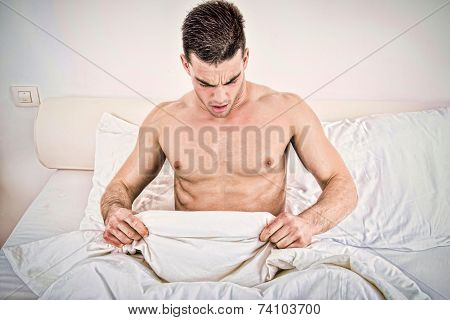 Half Naked Young Man In Bed  Looking Down At His Underwear