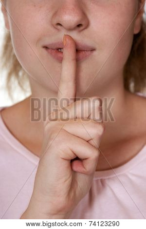 Woman holding finger to lips, gesture for silence