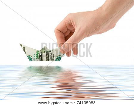 Hand launching money ship isolated on white background