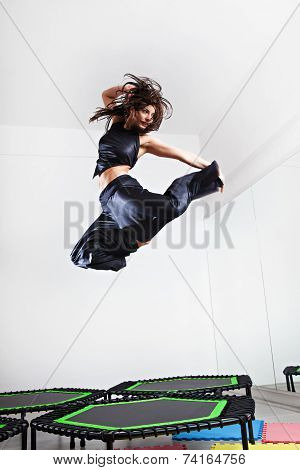 Jumping brunette woman on a trampoline