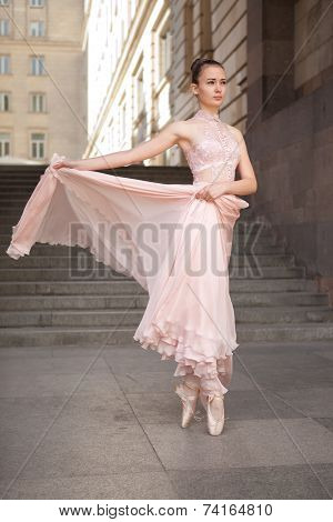 Young beautiful ballerina with pink dress dancing