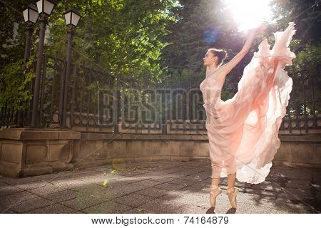 Young beautiful ballerina with pink dress dancing