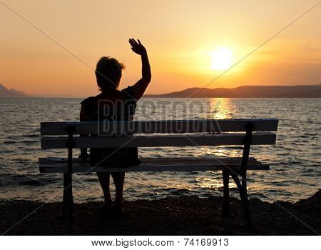 Woman on bench and sunset - vacation background