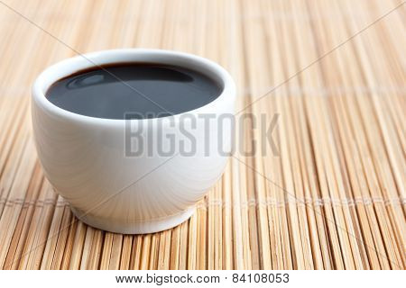 Soja sauce in small white dish.