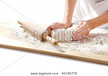 hands kneading dough on  board