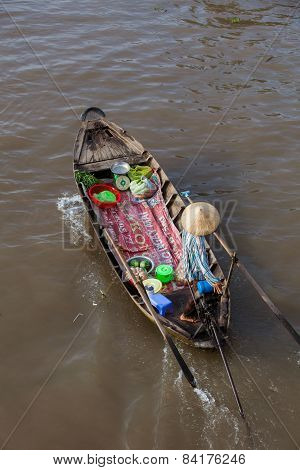 Woman on boat floating down Mekong river at Can Tho Floating Market