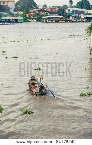 Woman on boat floating down Mekong river