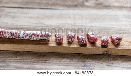 Cut Spanish Salami On The Wooden Board