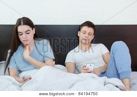 Young attractive caucasian couple with smartphones