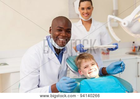 portrait of professional medical team and young patient during dental checkup