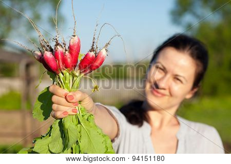 Woman Shows A Radish Sheaf