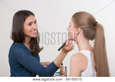 make-up artist doing make-up of a beautiful young girl