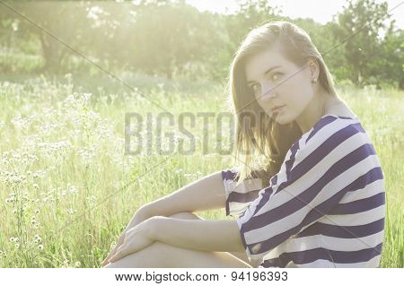 beautiful young woman sitting on hay.