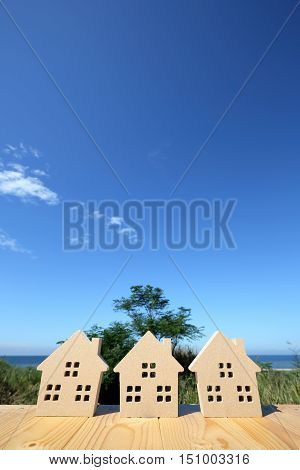 wooden toy house against clear blue sky background