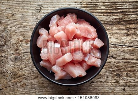 Raw Cut Meat Chunks In Black Bowl, From Above