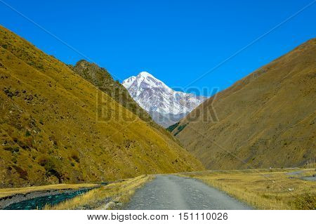 road to village Sno, caucasus mountains, mountain river, snowy peak Mkinvari and road